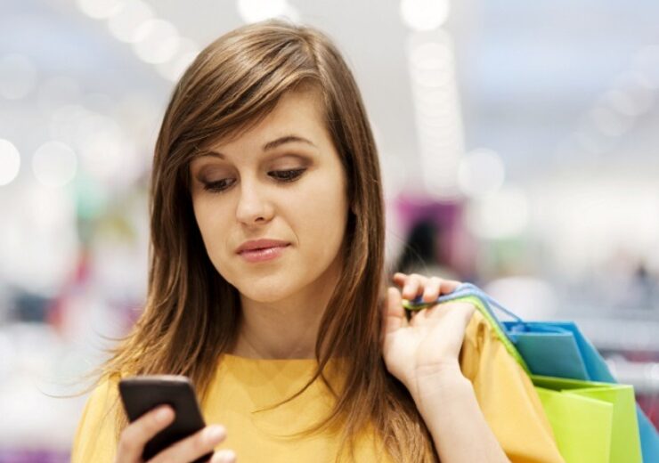 Young woman texting on mobile phone in store
